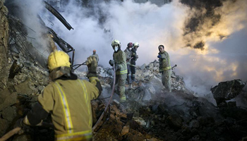 Iranian firefighters work at building collapse site in Tehran