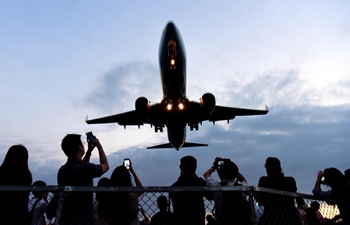 People observe passing airplane near Taipei Songshan Airport